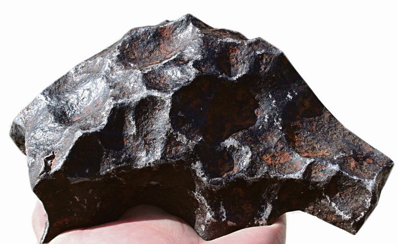 Fragment meteorytu żelaznego Gibeon z charakterystyczną powierchnią, jakby umiędloną palcami.
